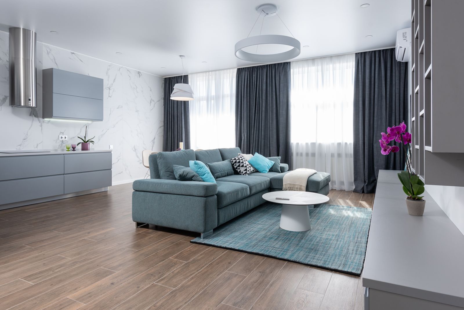 A finished, styled living room with a sofa, coffee table and warm decor